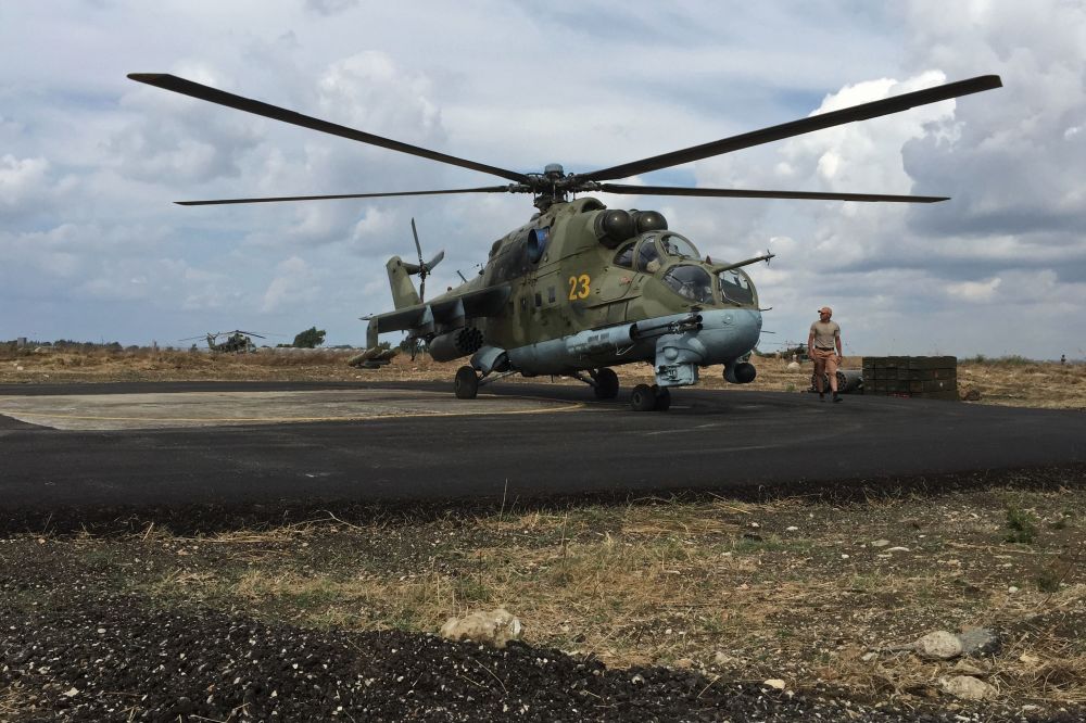 پرسنل فنی در کنار بالگرد تهاجمی می ـ 24 روسیه در  فرودگاه نظامی حمیمیم در سوریه